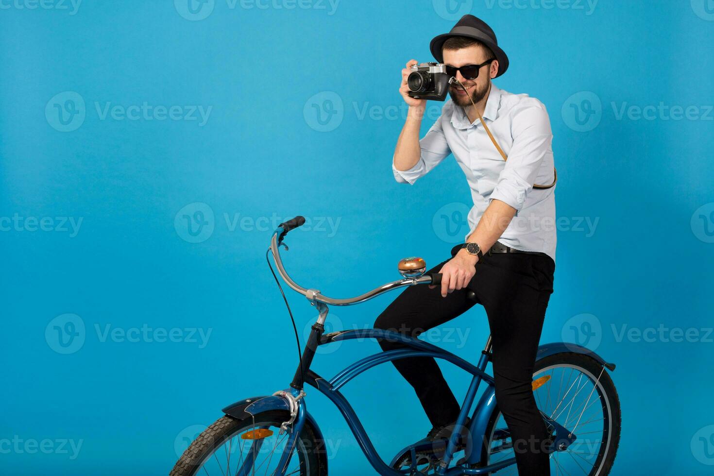 young handsome smiling happy man traveling on hipster bicycle photo