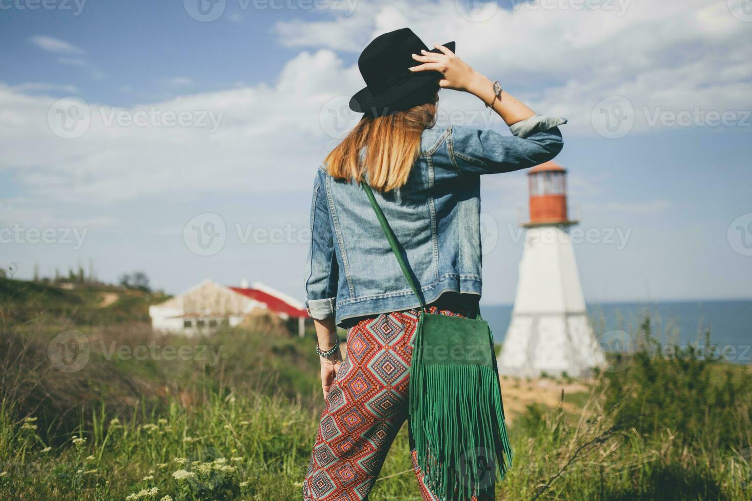 young woman in nature, lighthouse denim jacket, black hat, summer, stylish accessories photo