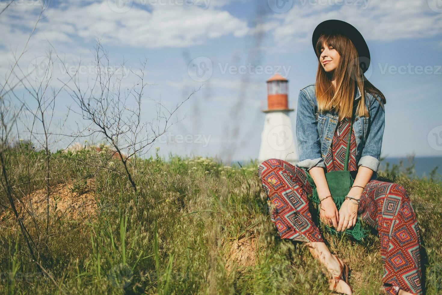 young woman in nature, lighthouse denim jacket, black hat, summer, stylish accessories photo
