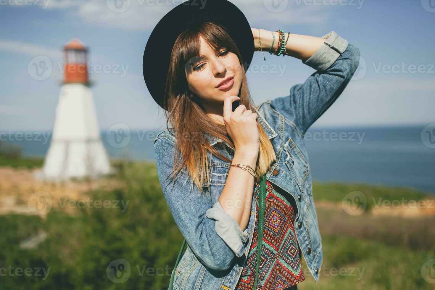 young woman in nature, lighthouse denim jacket, black hat, summer, stylish accessories photo