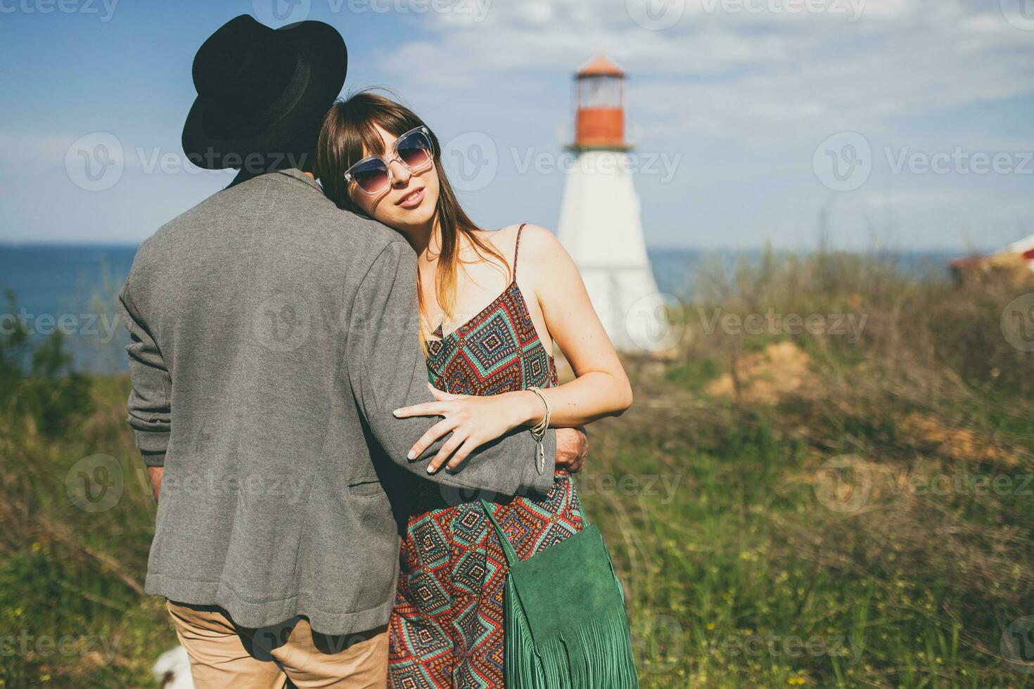 young hipster couple indie style in love walking in countryside, lighthouse on background photo