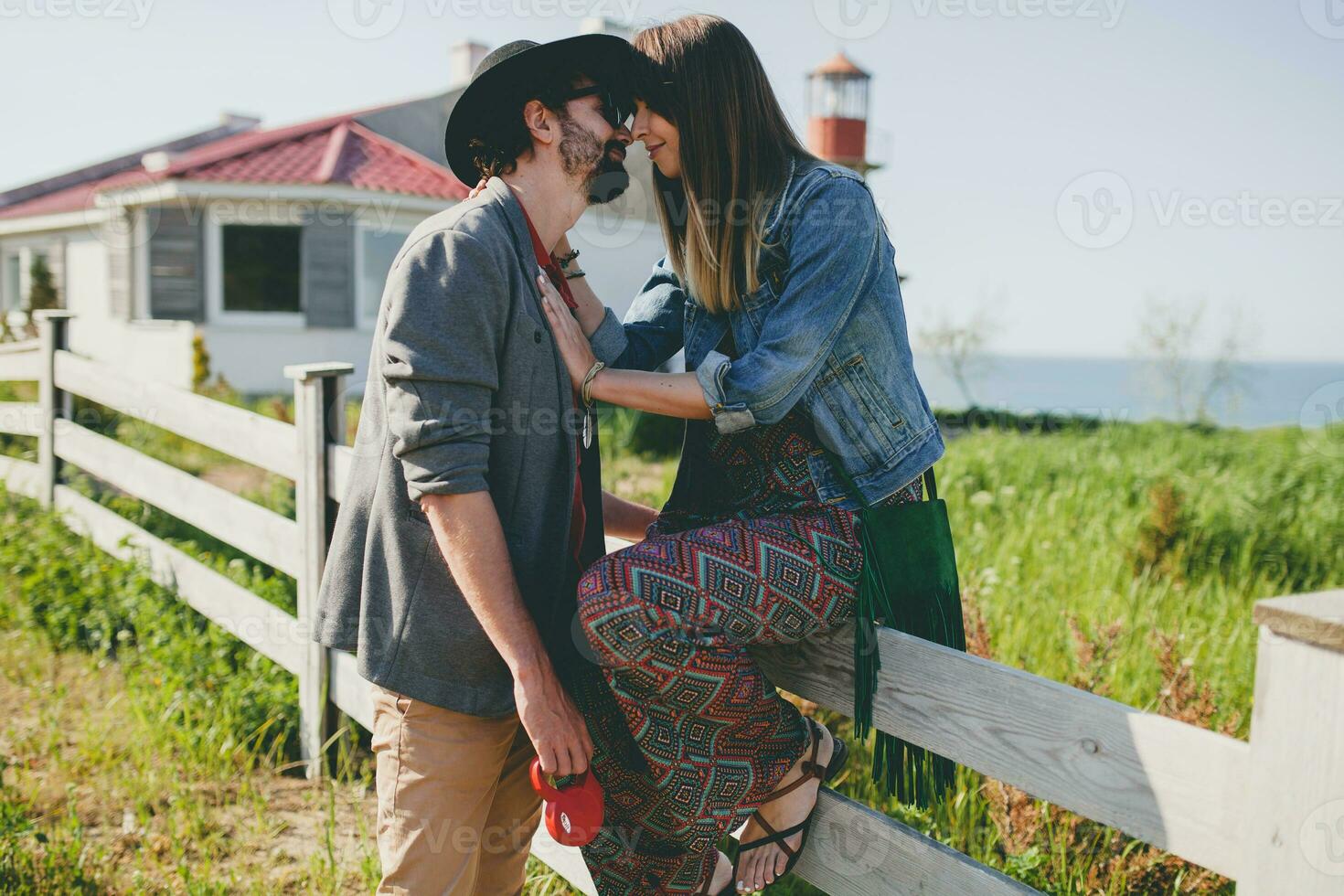 young stylish hipster couple in love walking with dog in countryside photo