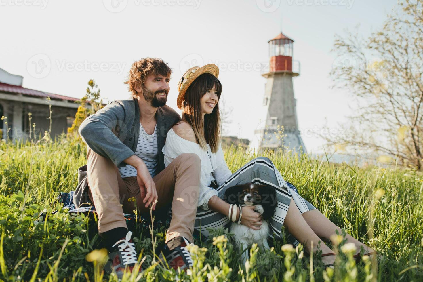sitting in grass young stylish hipster couple in love walking with dog in countryside photo
