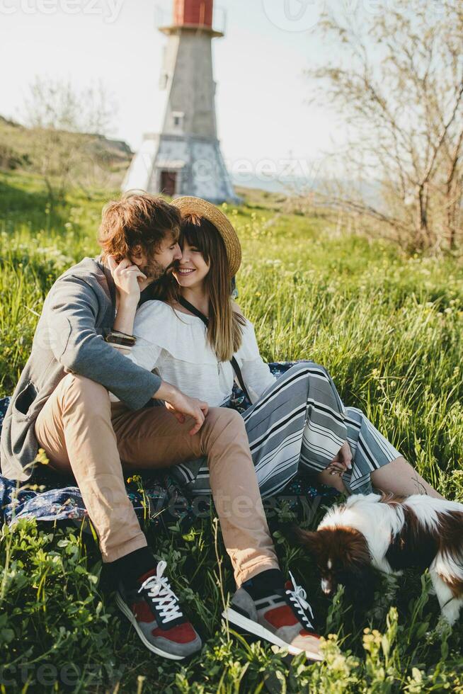 sitting in grass young stylish hipster couple in love walking with dog in countryside photo