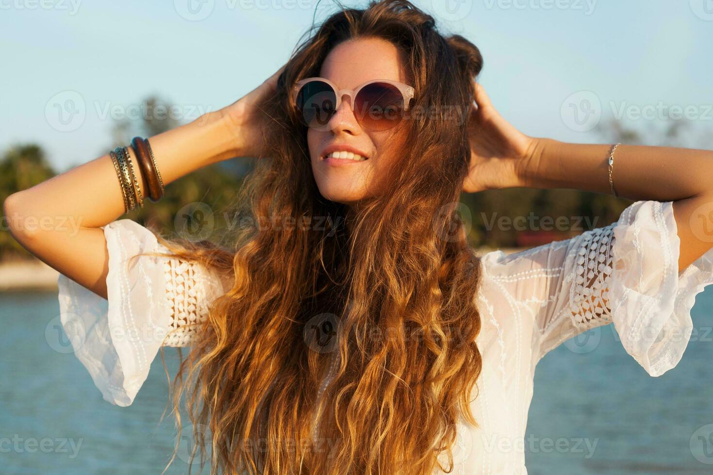 slim beautiful woman in white cotton dress walking on tropical beach photo