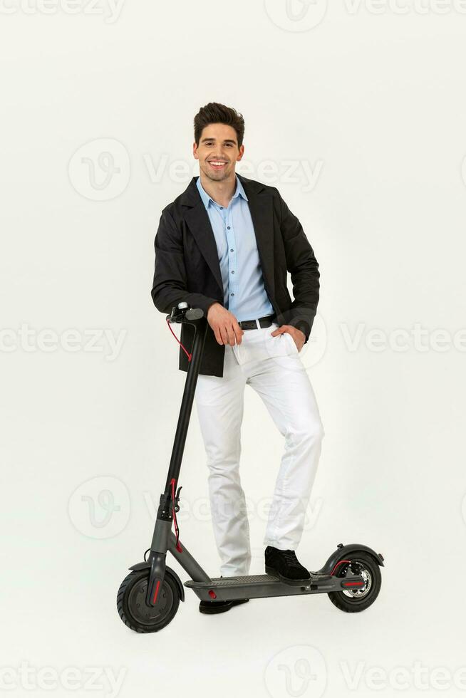 handsome man riding on electic kick scooter isolated on white studio background photo