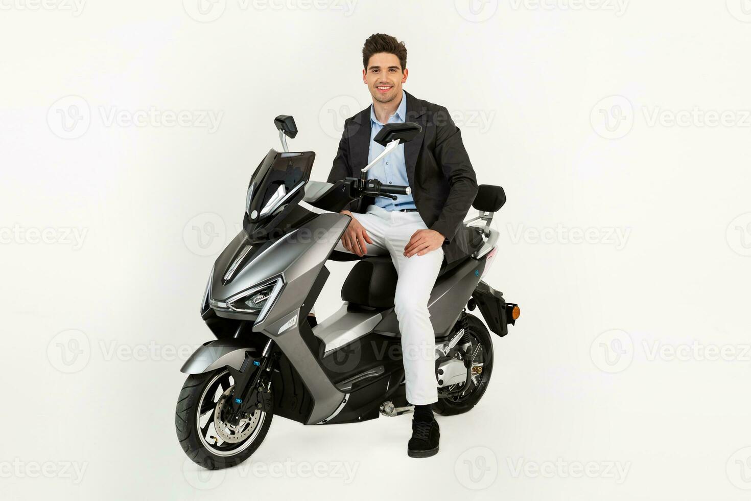 handsome man riding on electic motorbike scooter isolated on white studio background photo