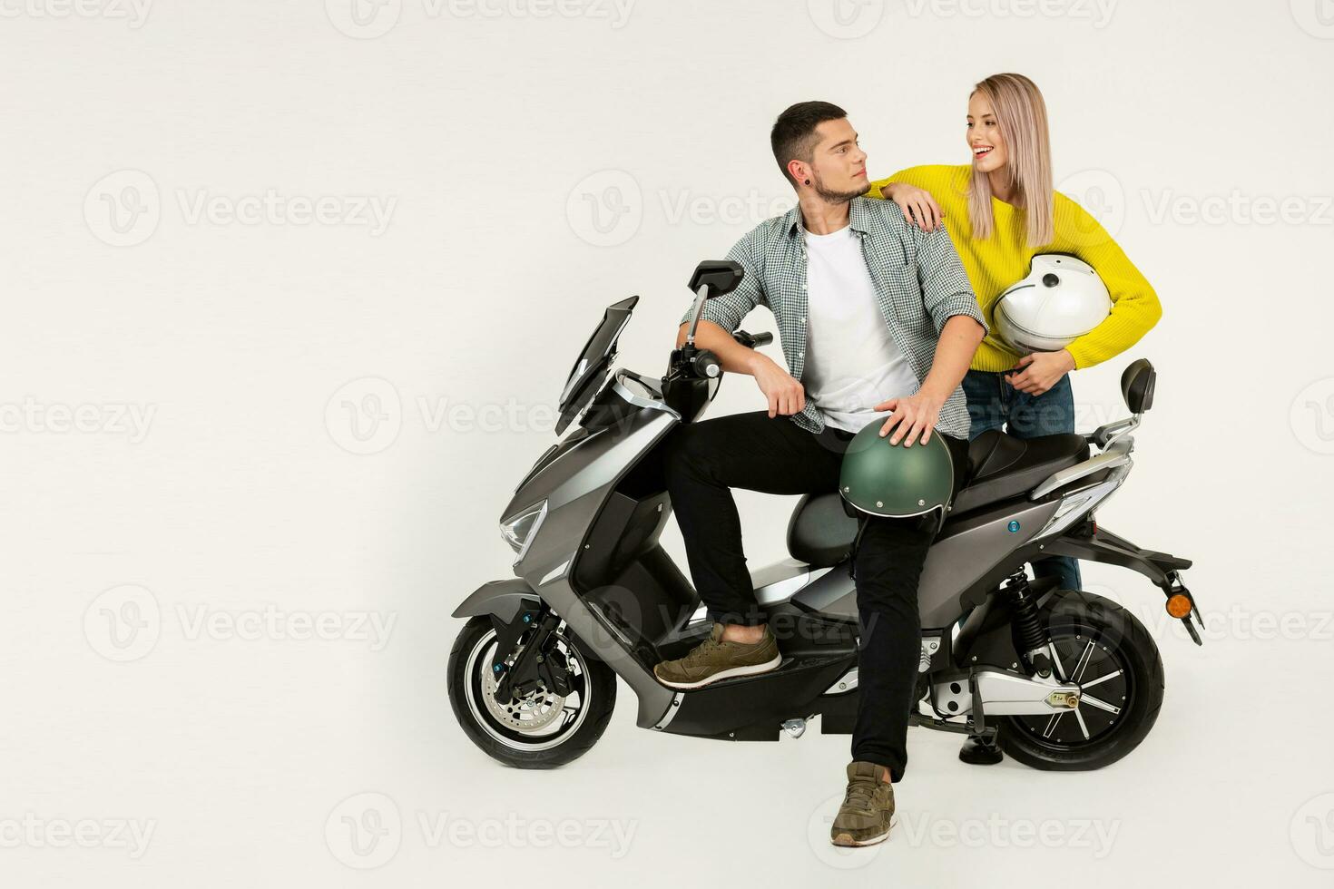 young attractive couple riding an electric motorbike scooter happy having fun together photo