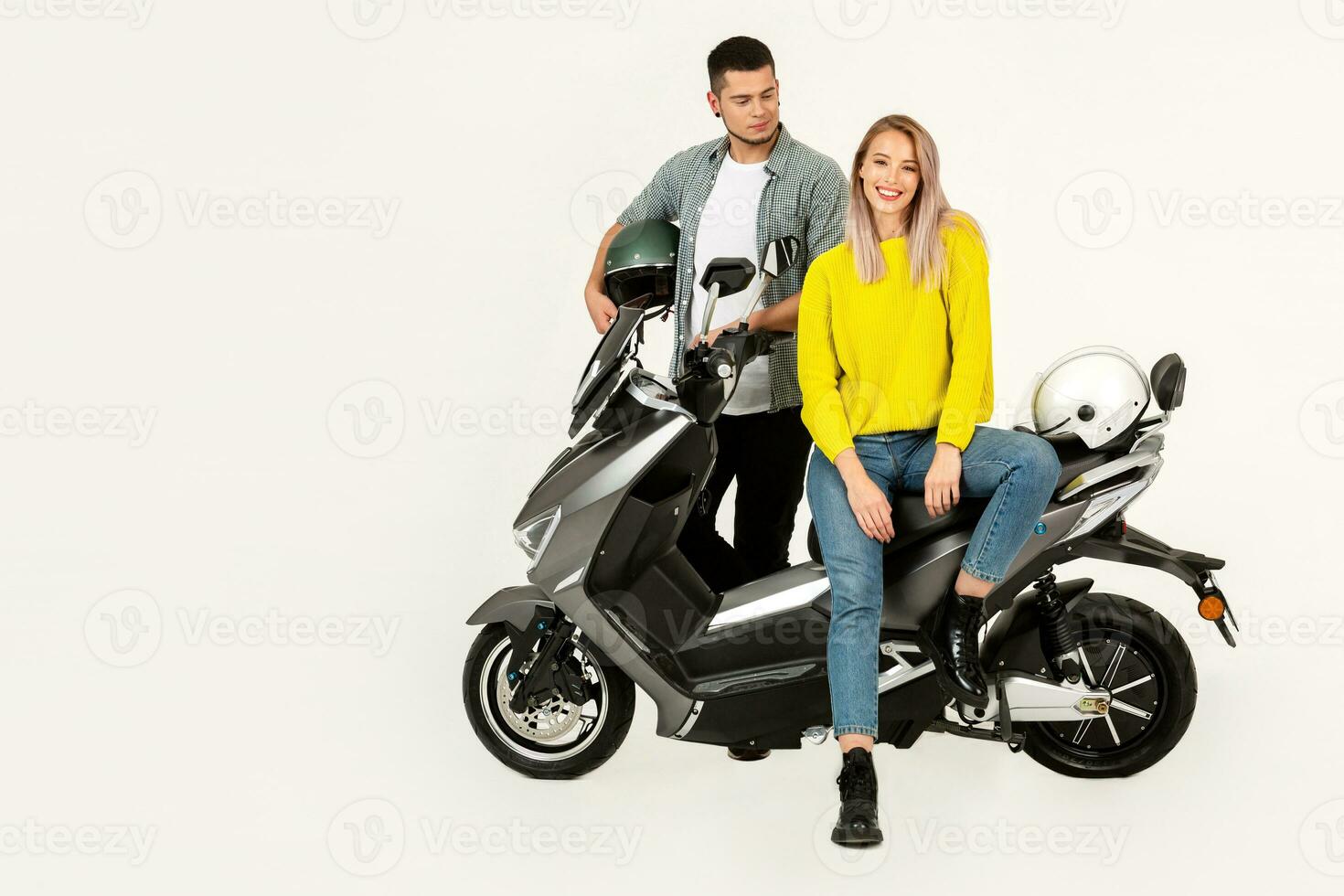 young attractive couple riding an electric motorbike scooter happy having fun together photo