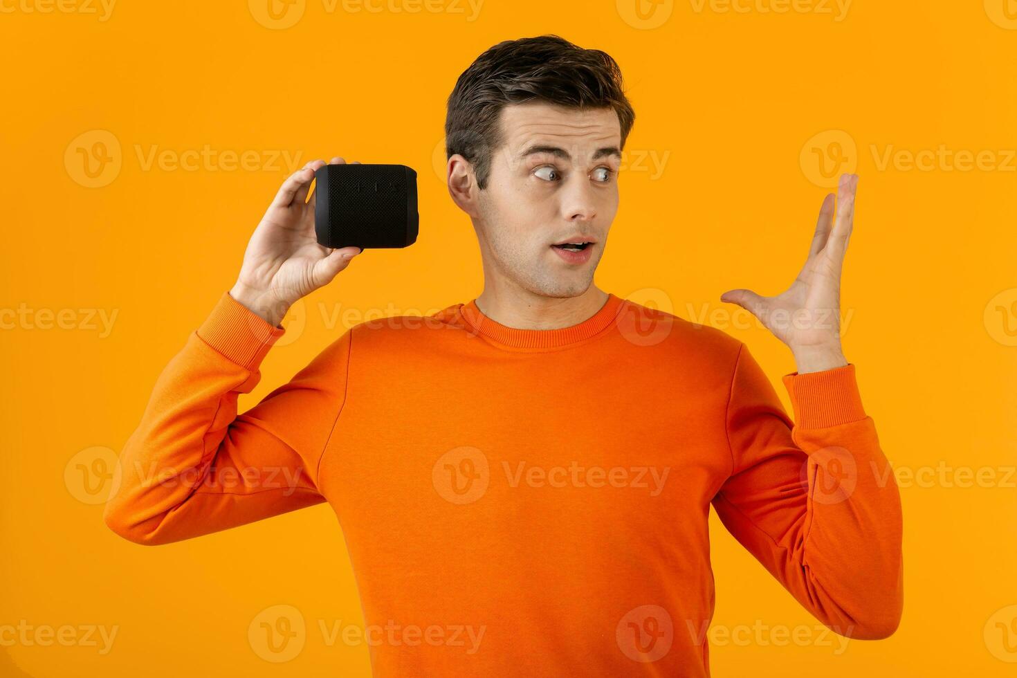 stylish young man holding wireless speaker photo