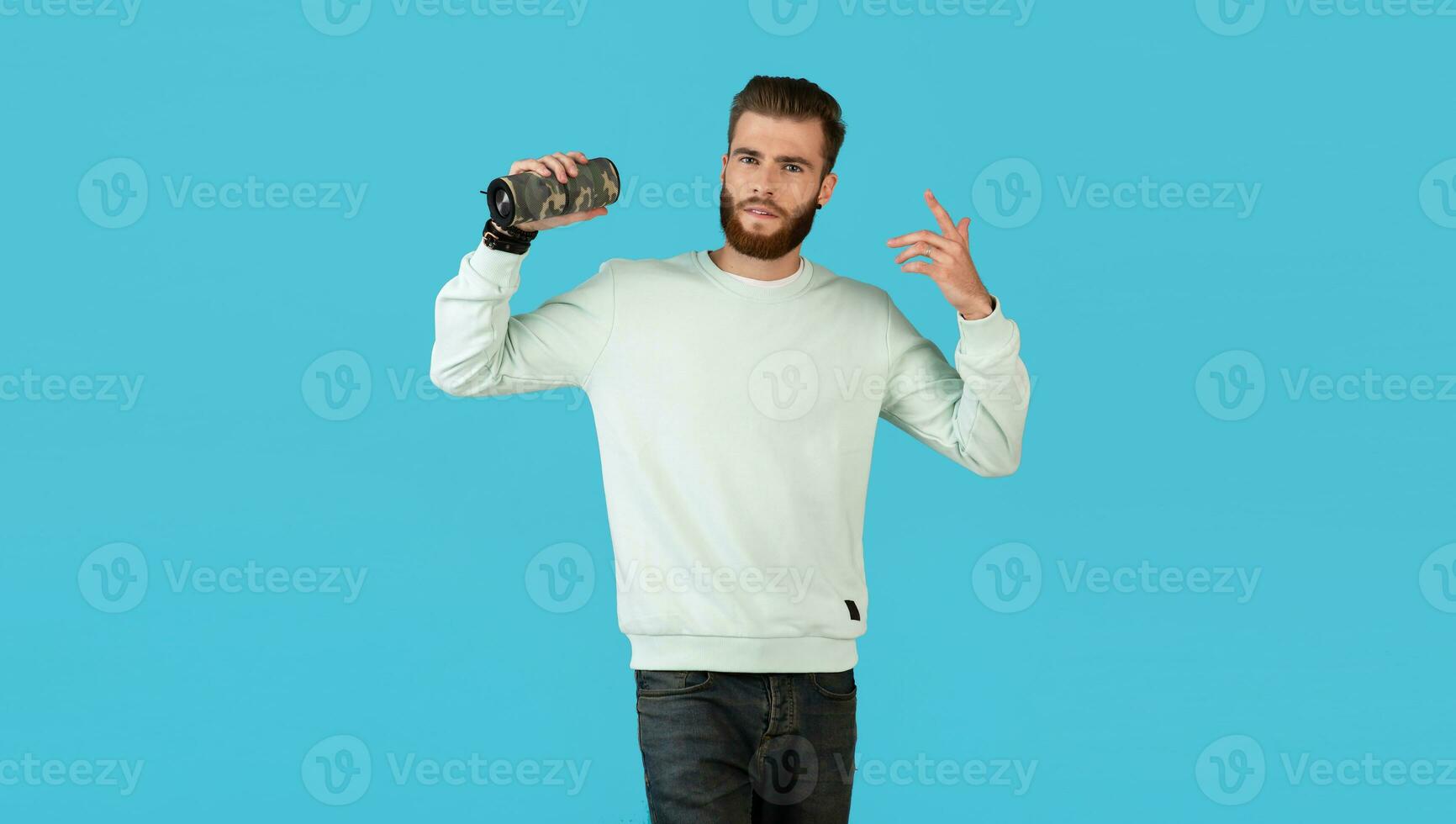 stylish young man holding wireless speaker photo