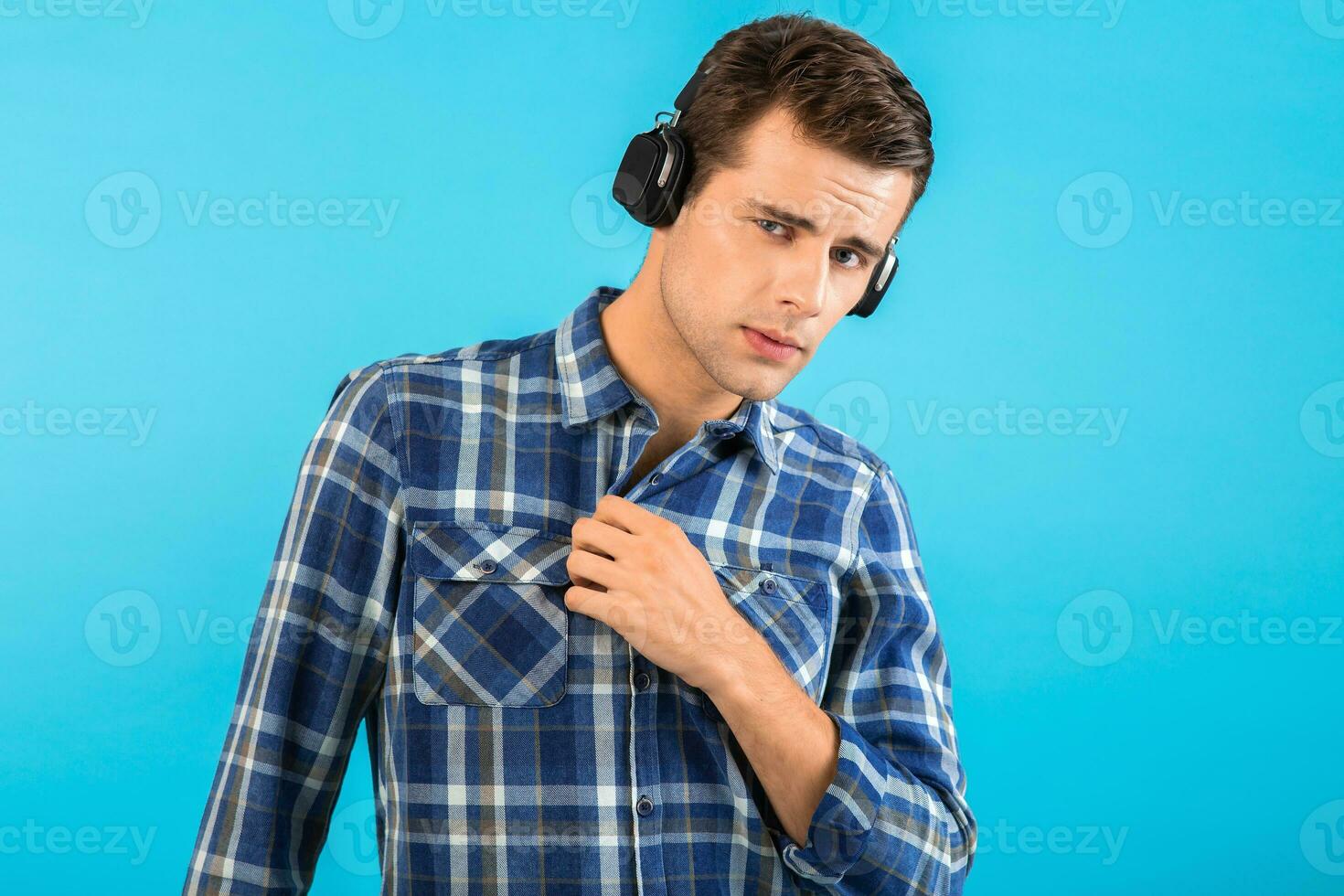 elegante joven hombre escuchando a música en inalámbrico auriculares foto