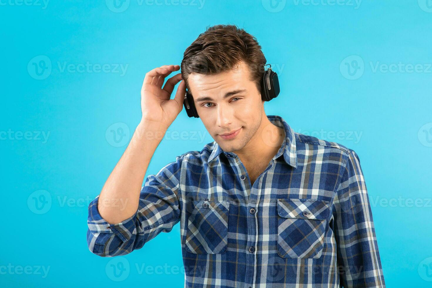 elegante joven hombre escuchando a música en inalámbrico auriculares foto