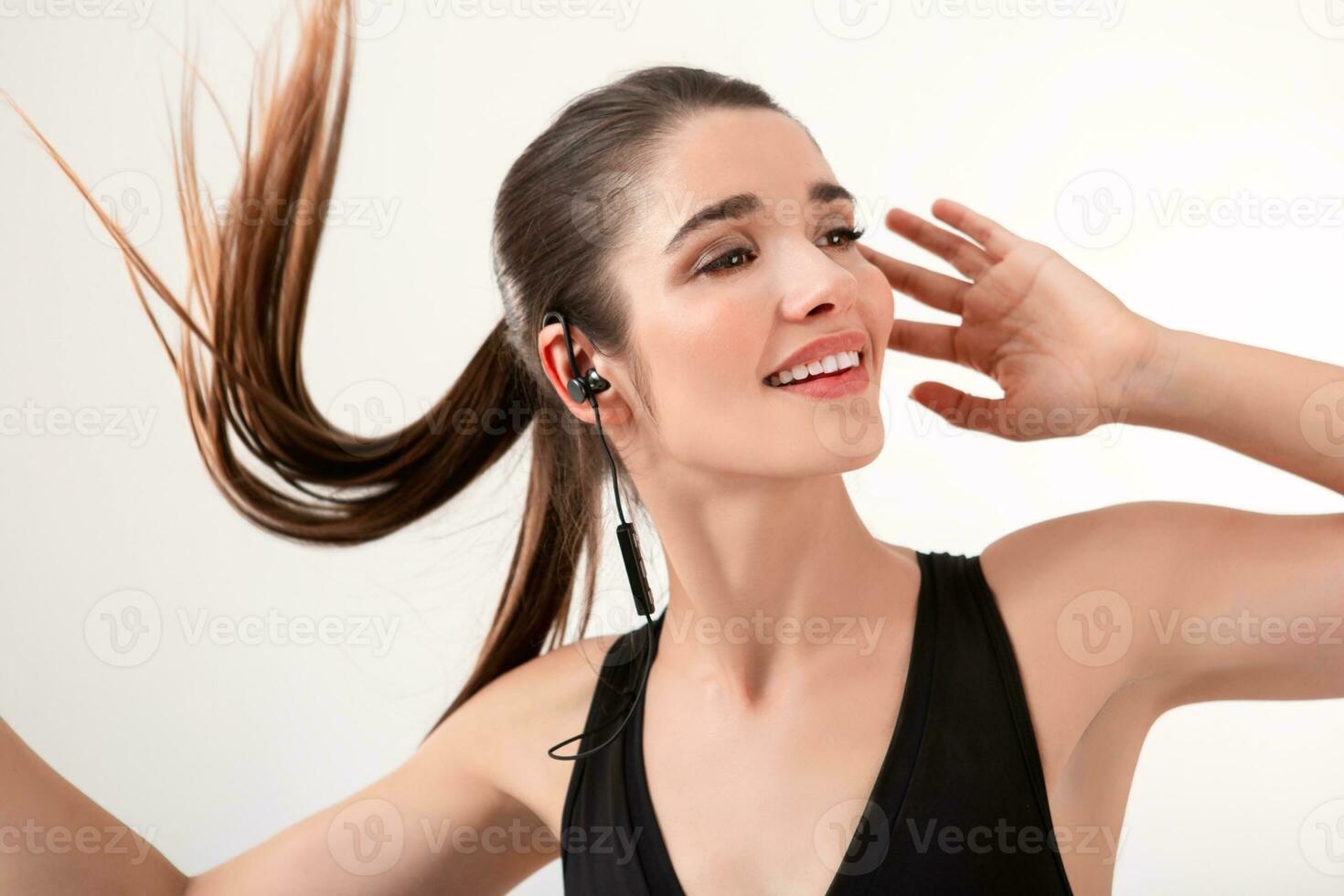 attractive woman in jogging black top listening to music on earphones photo