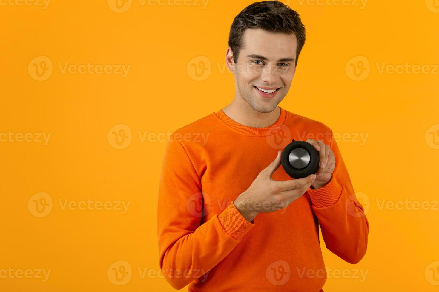 stylish young man holding wireless speaker photo