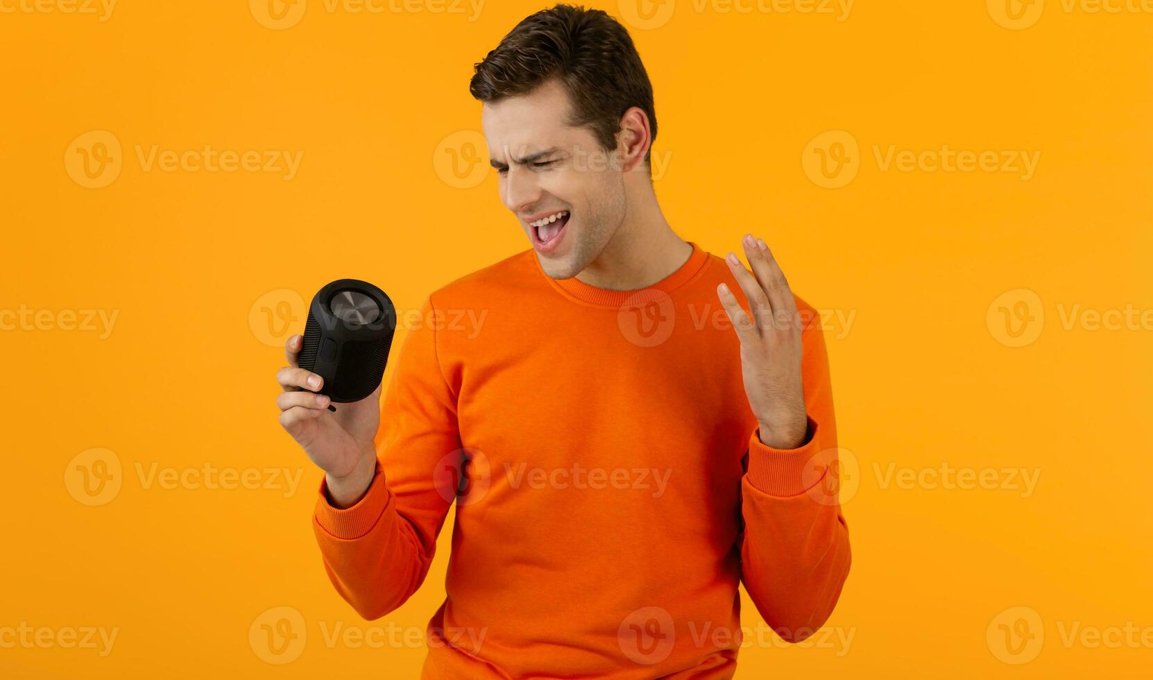 stylish young man holding wireless speaker photo