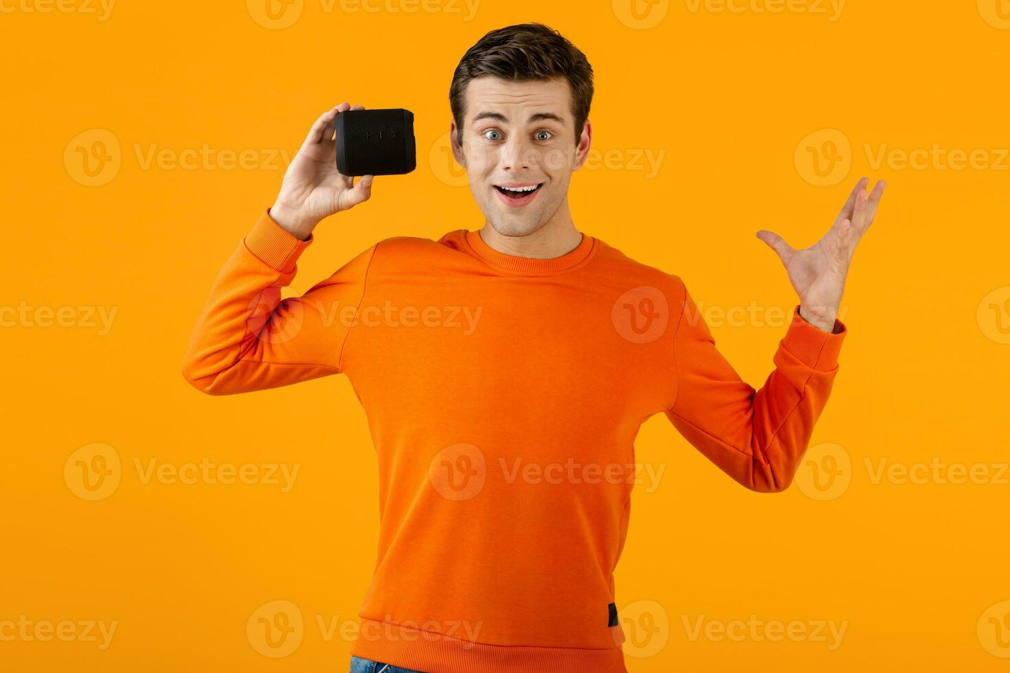 stylish young man holding wireless speaker photo