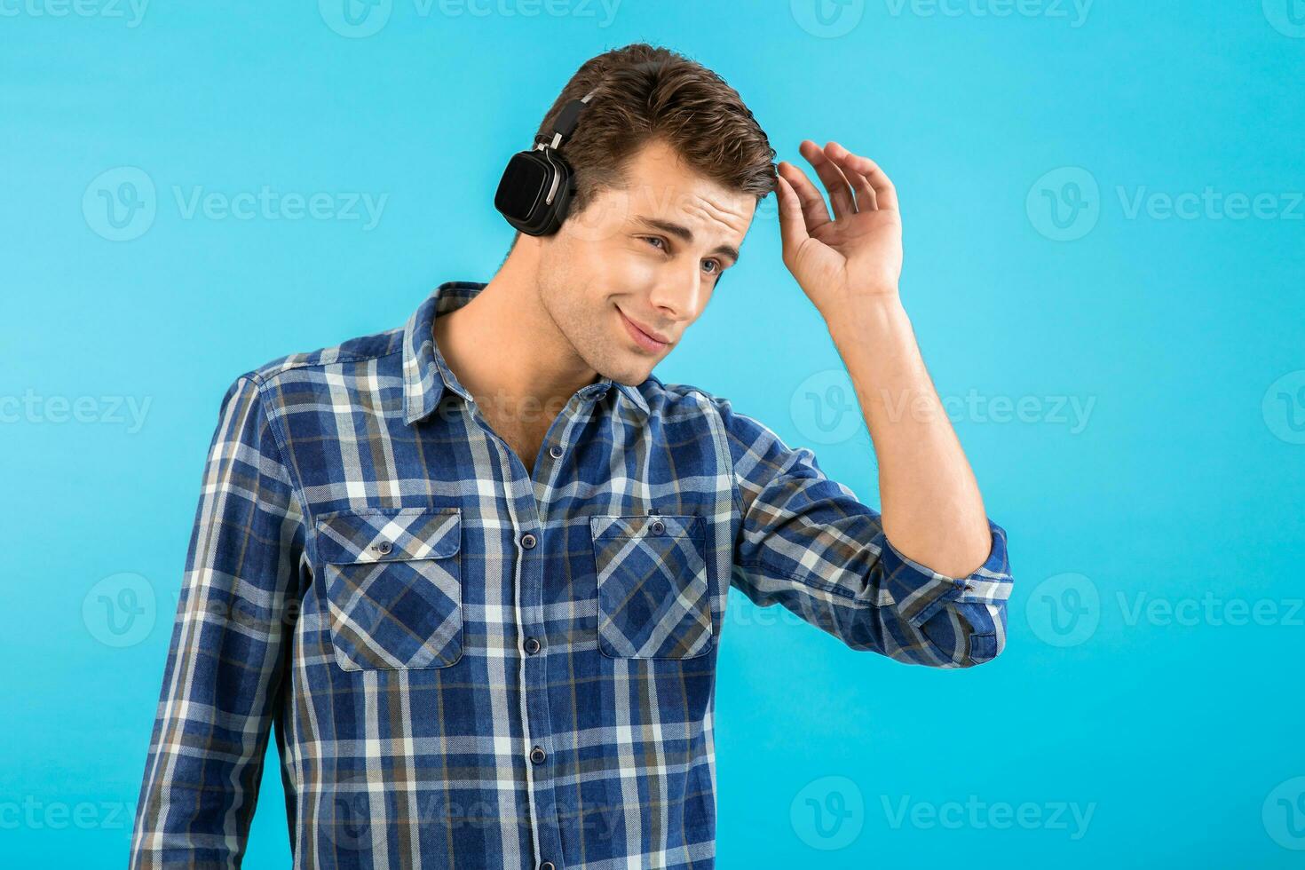 elegante joven hombre escuchando a música en inalámbrico auriculares foto