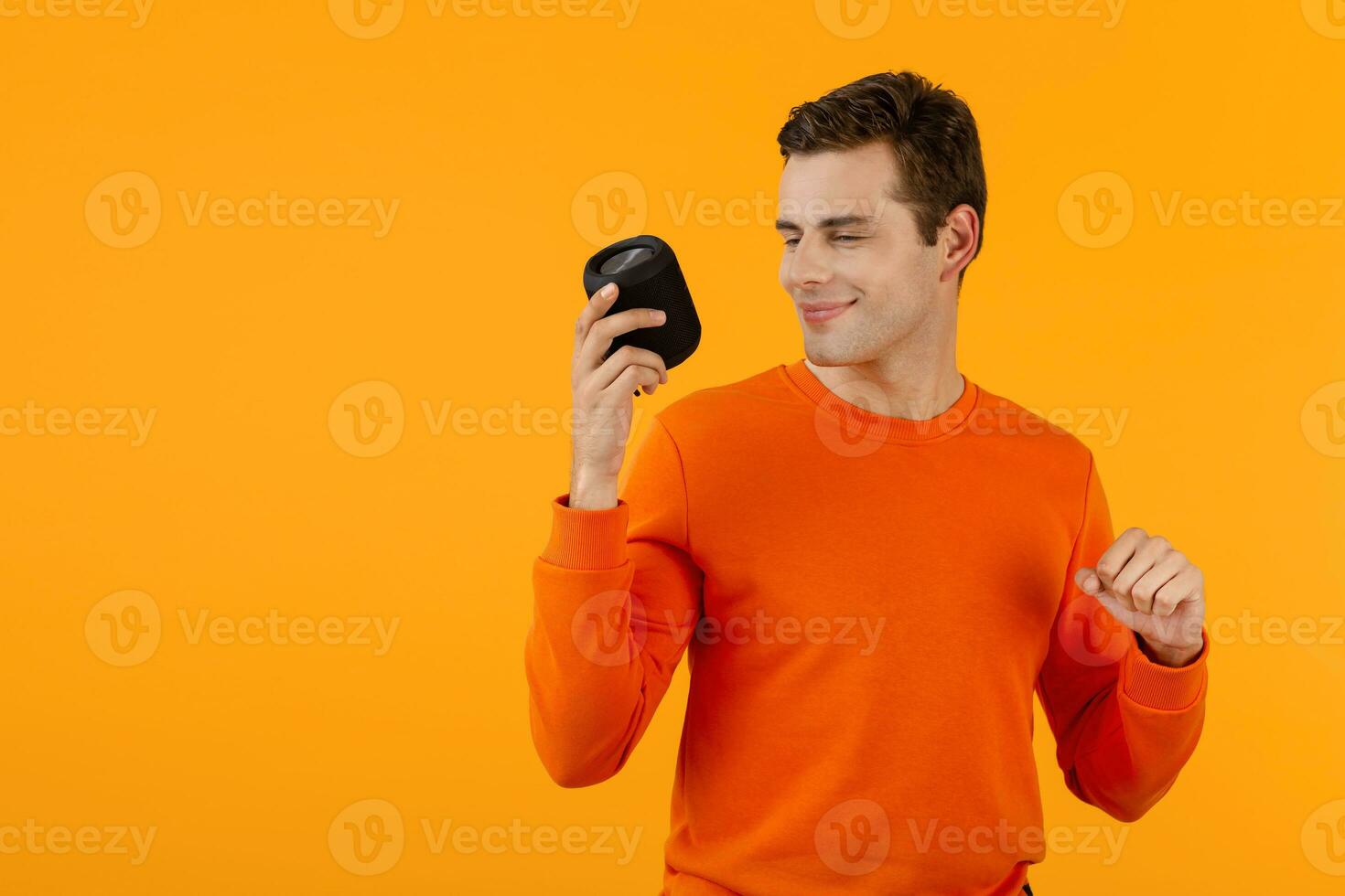 stylish young man holding wireless speaker photo