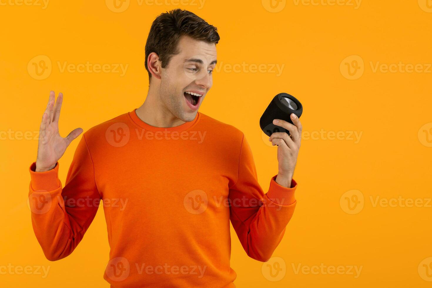 stylish young man holding wireless speaker photo