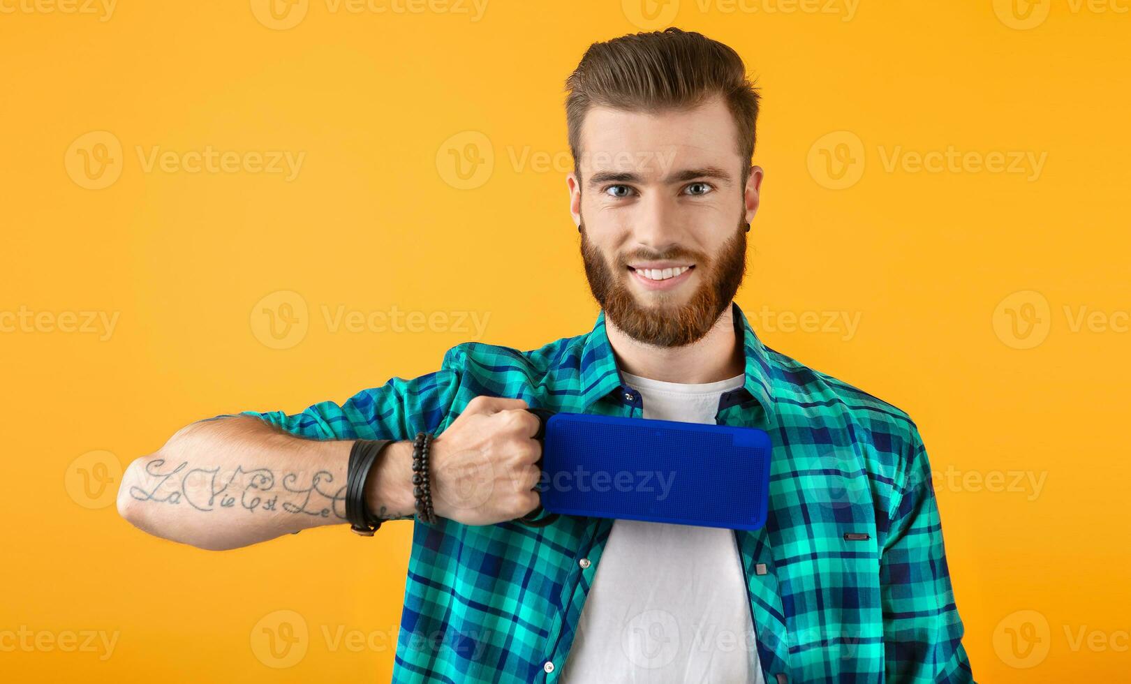 stylish young man holding wireless speaker photo