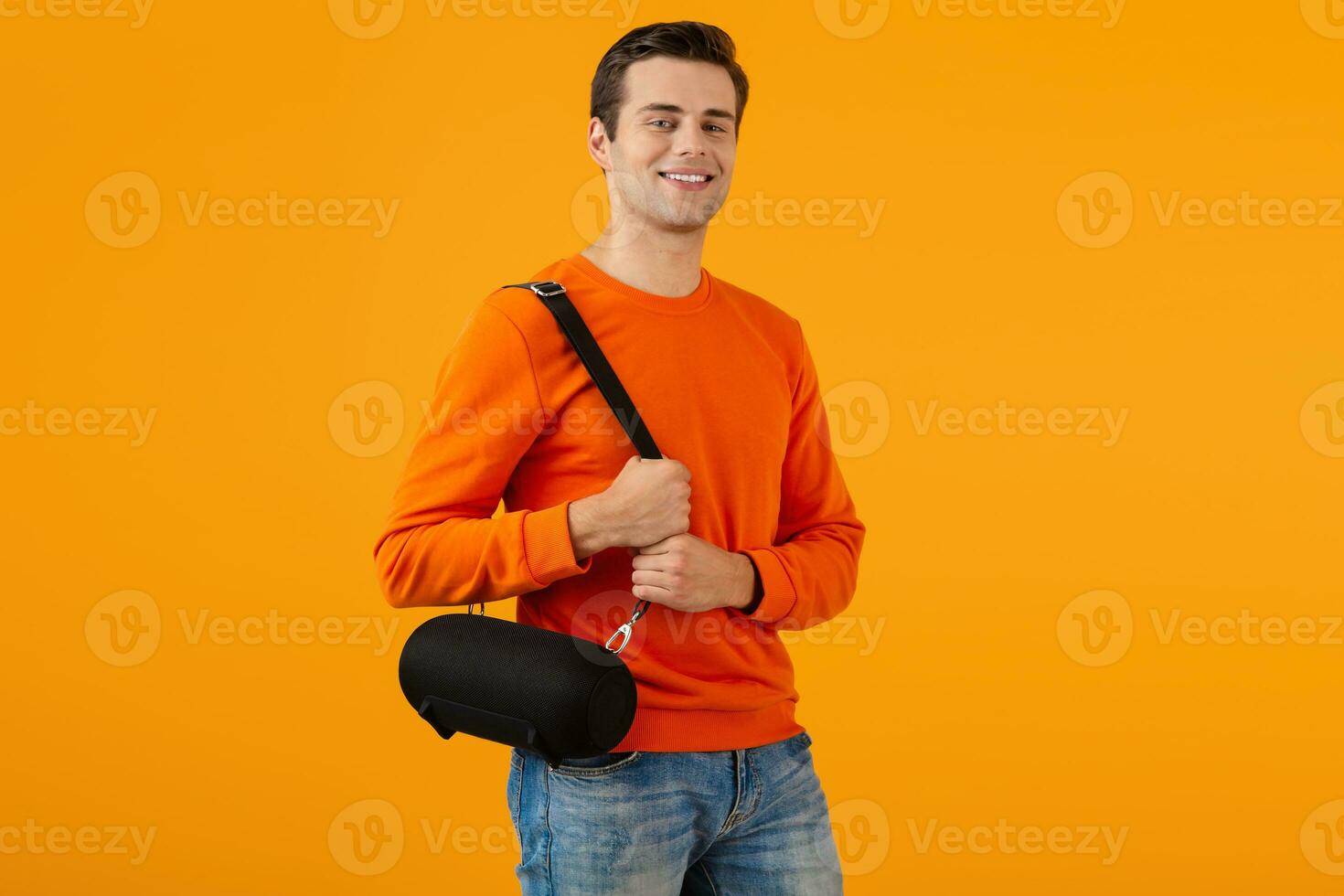 stylish young man holding wireless speaker photo