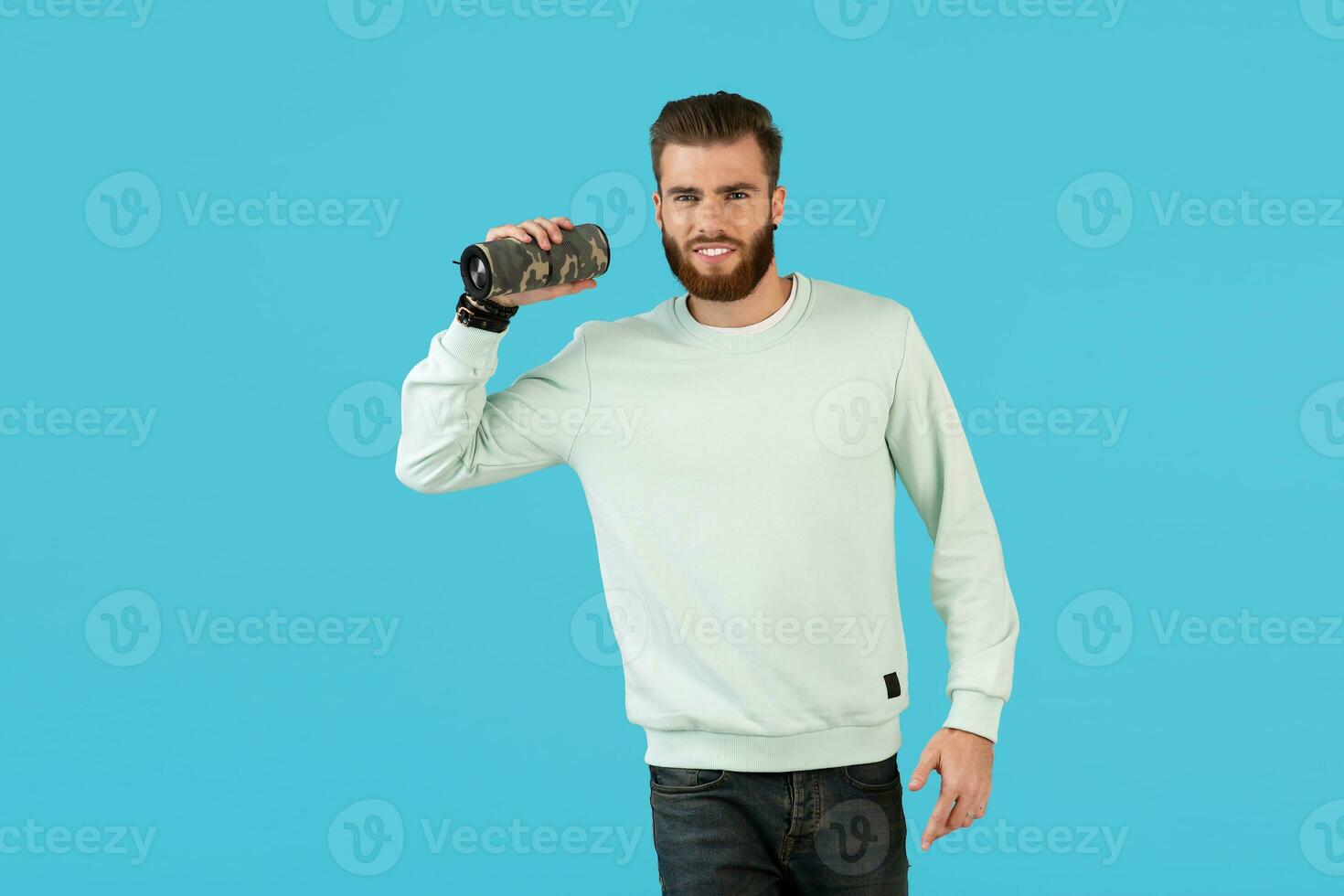 stylish young man holding wireless speaker photo