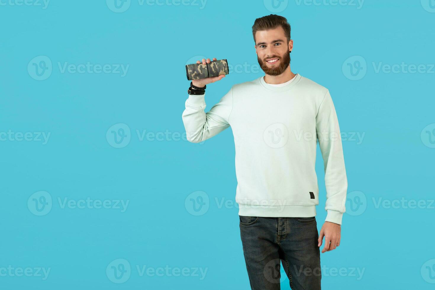 elegante joven hombre participación inalámbrico altavoz foto