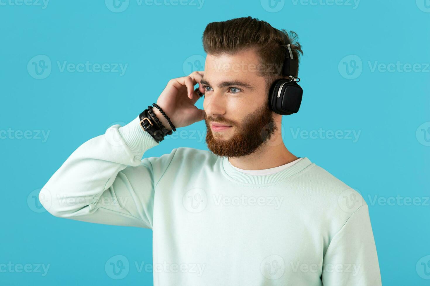 stylish young man listening to music on wireless headphones photo