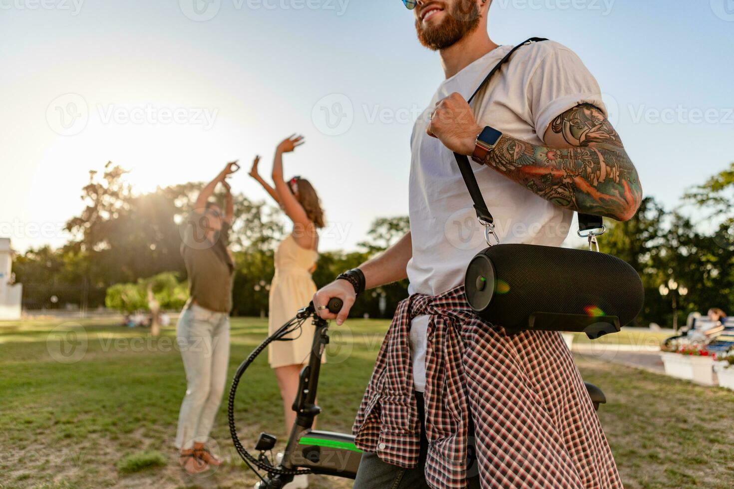 company of friends having fun together in park listening to music photo