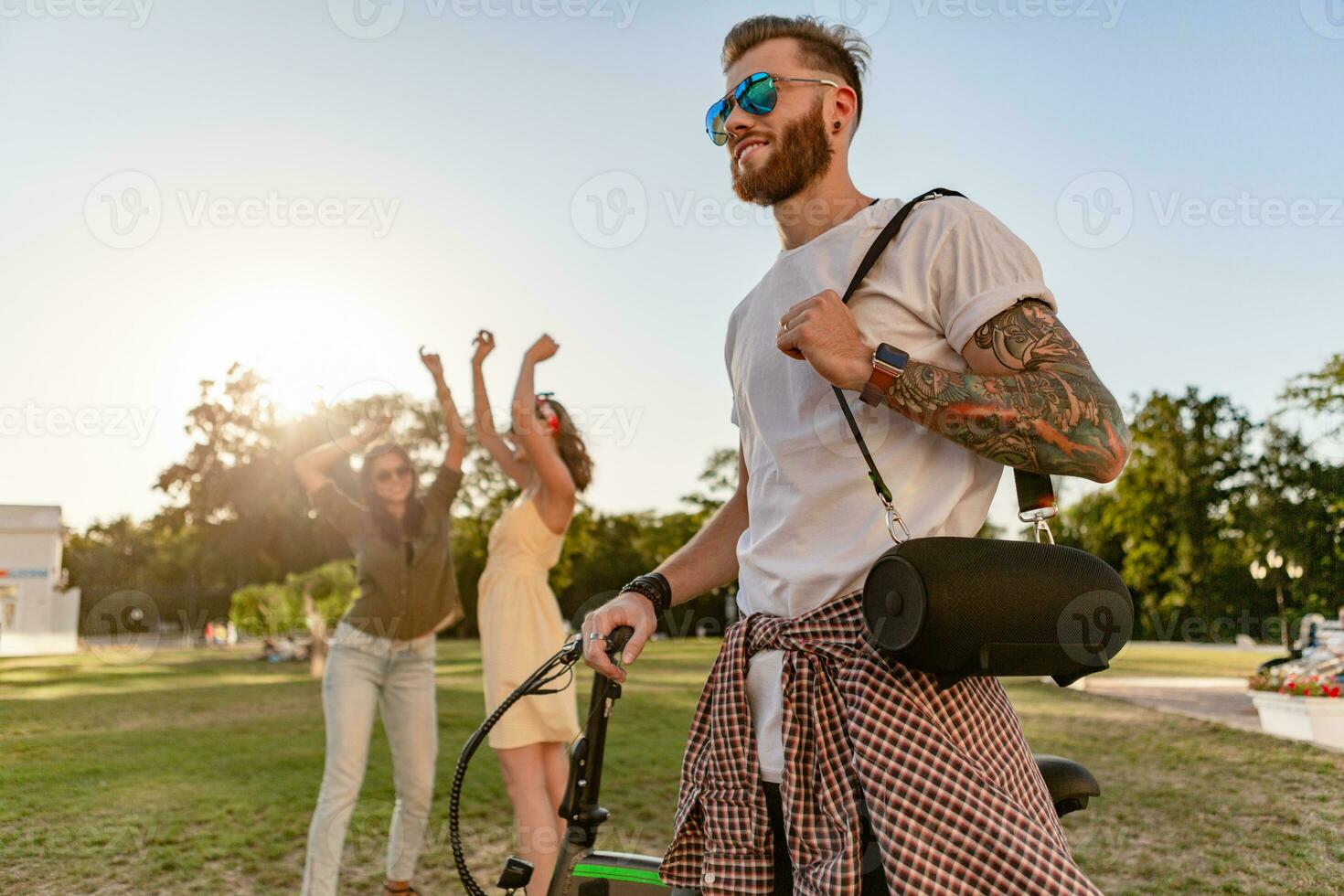 company of friends having fun together in park listening to music photo