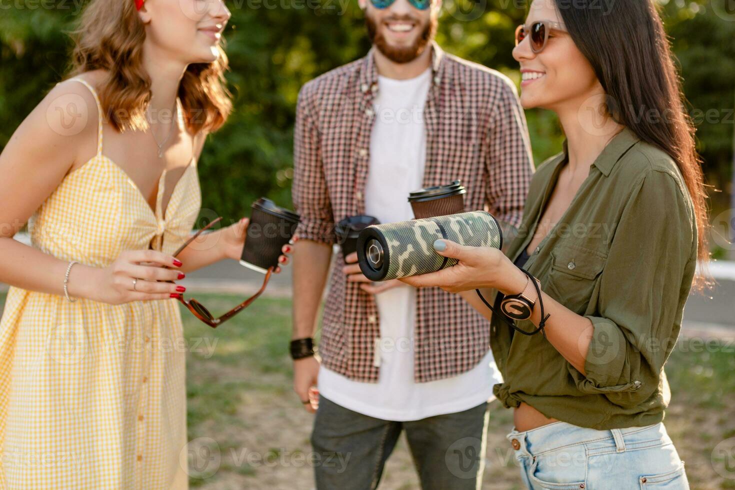 company of friends having fun together in park listening to music photo