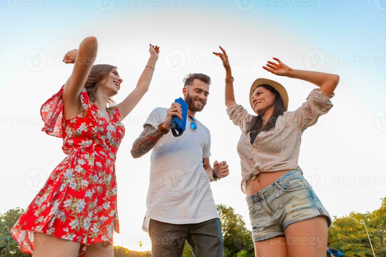 company of friends having fun together in park listening to music photo