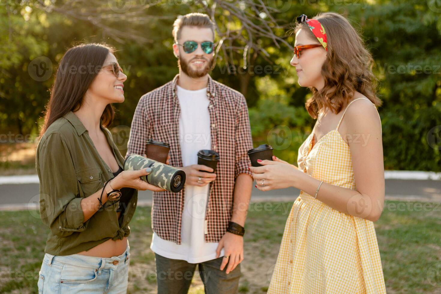 company of friends having fun together in park listening to music photo