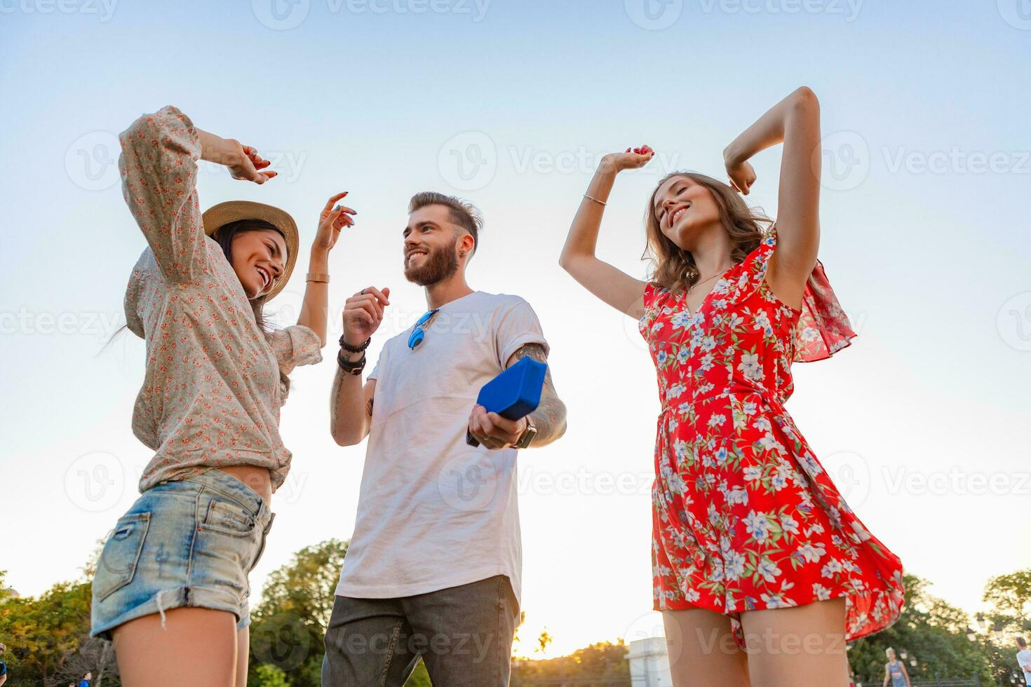 company of friends having fun together in park listening to music photo