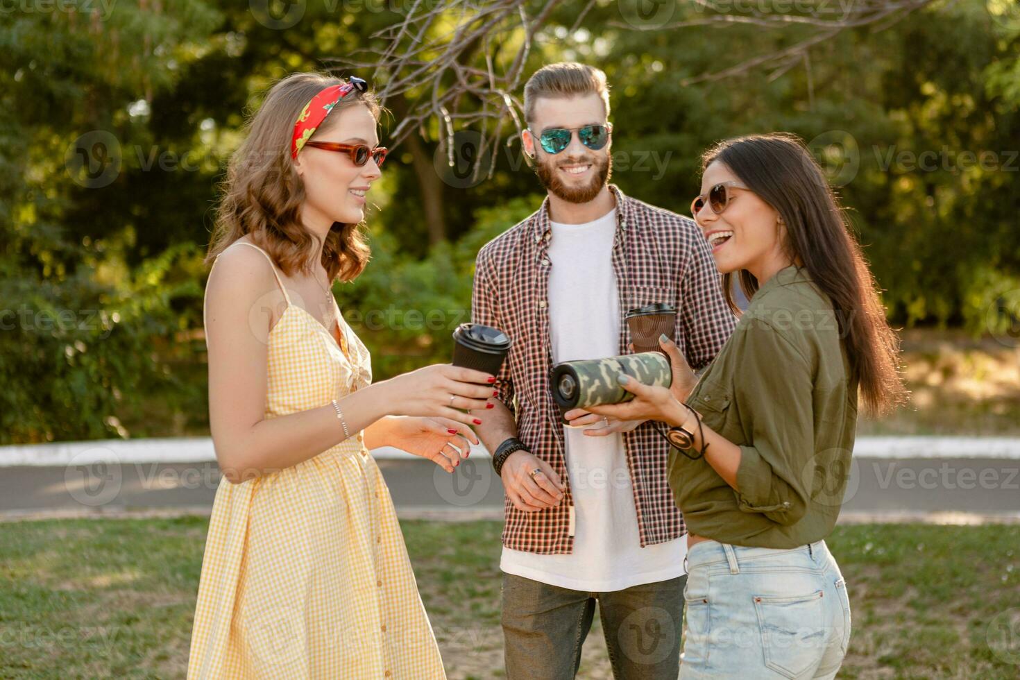 company of friends having fun together in park listening to music photo