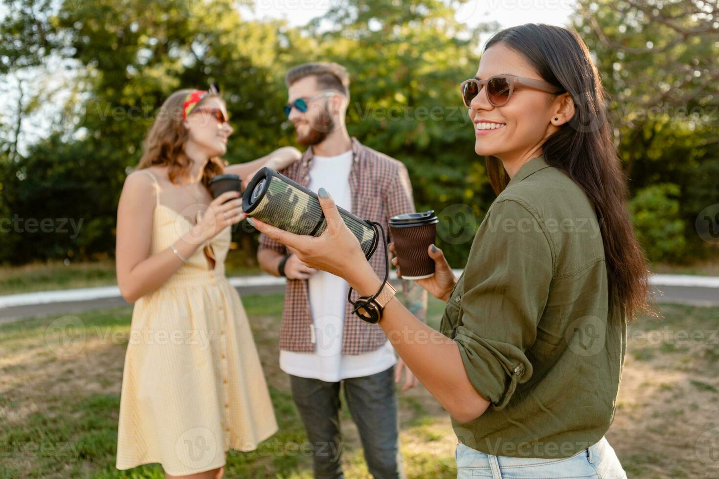 company of friends having fun together in park listening to music photo