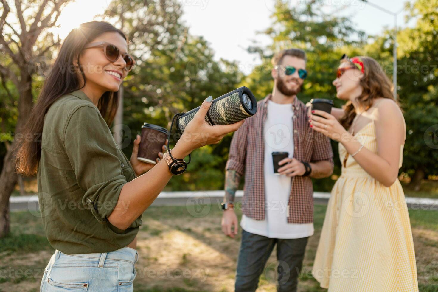 company of friends having fun together in park listening to music photo