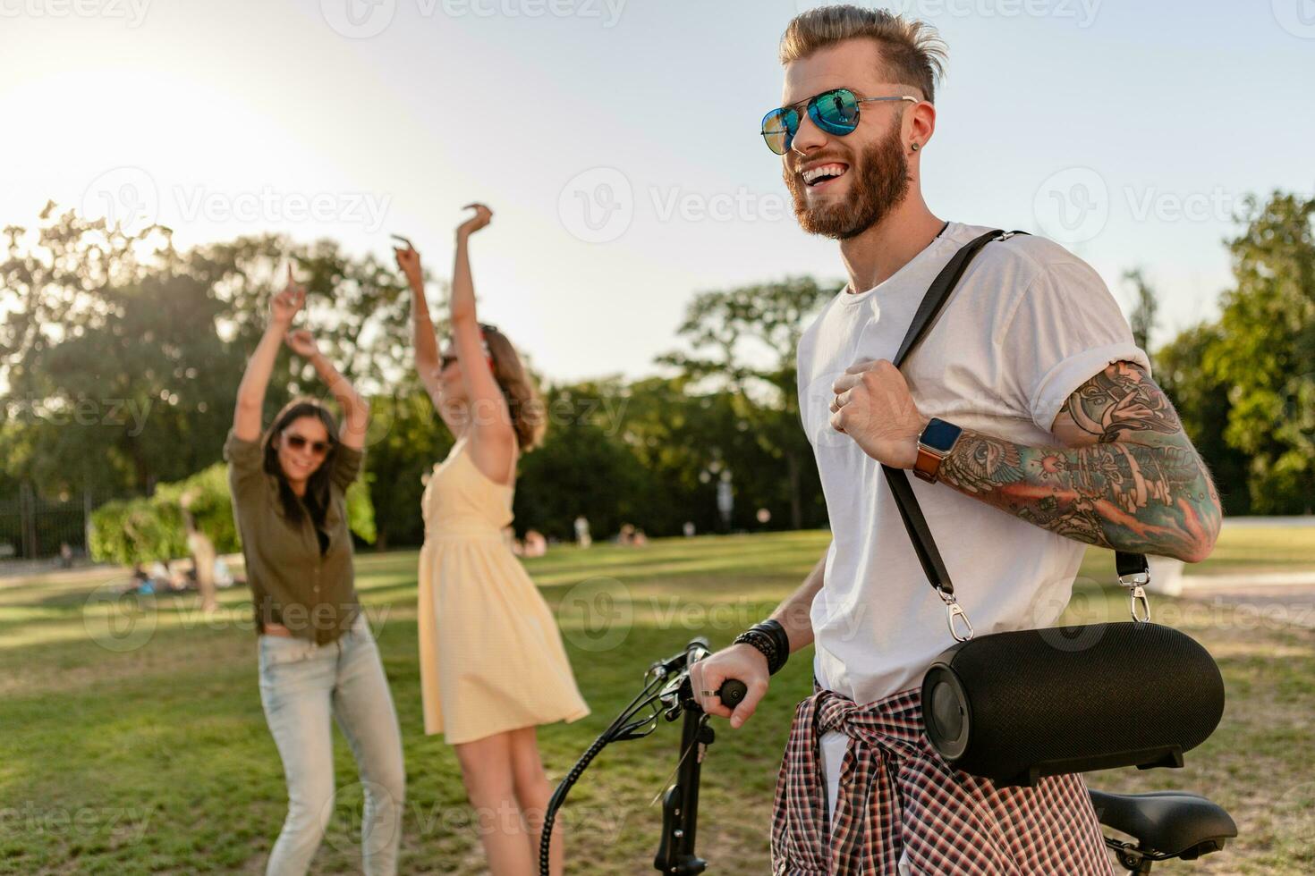 company of friends having fun together in park listening to music photo