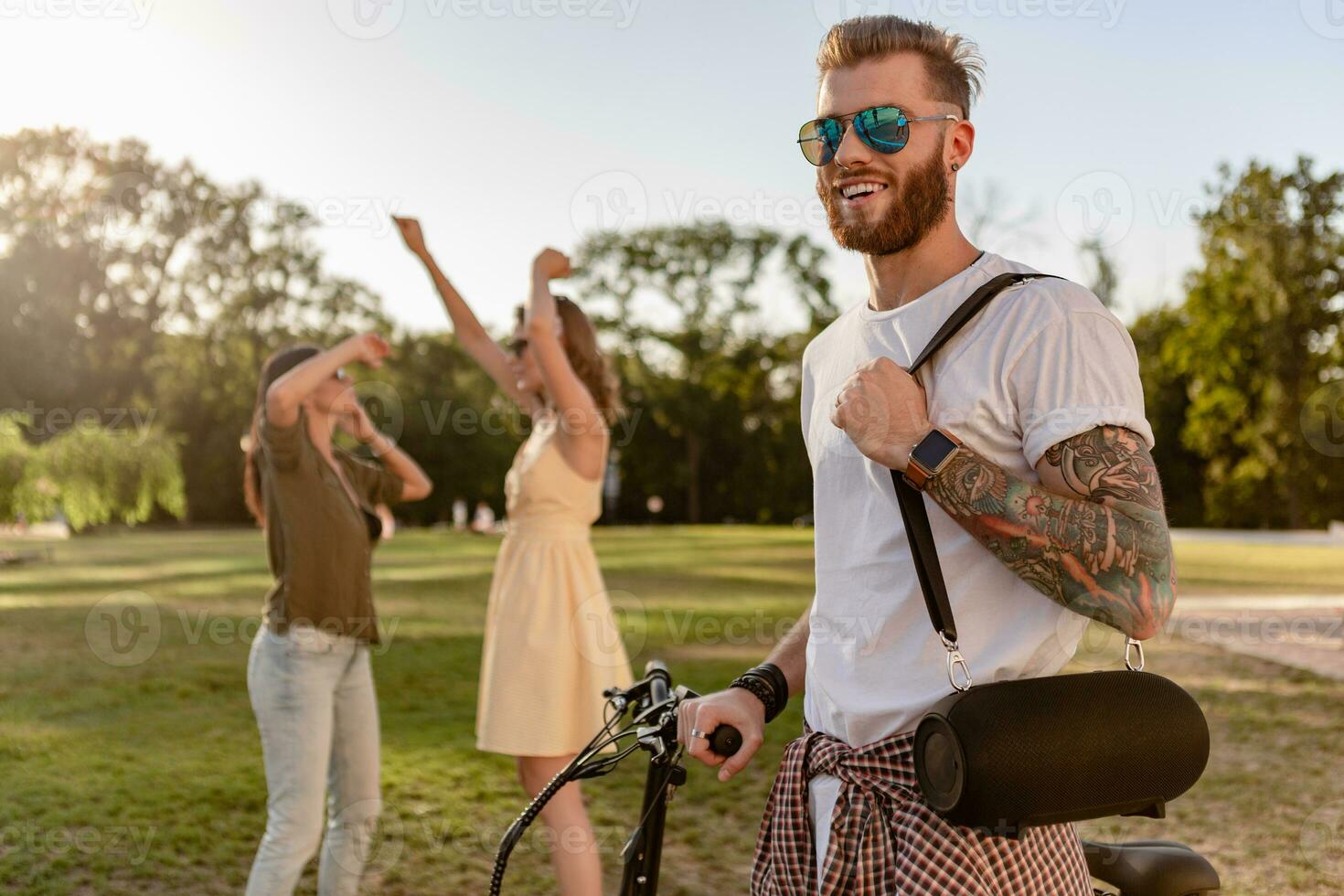 company of friends having fun together in park listening to music photo