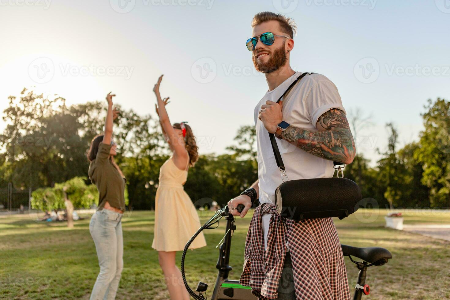 company of friends having fun together in park listening to music photo