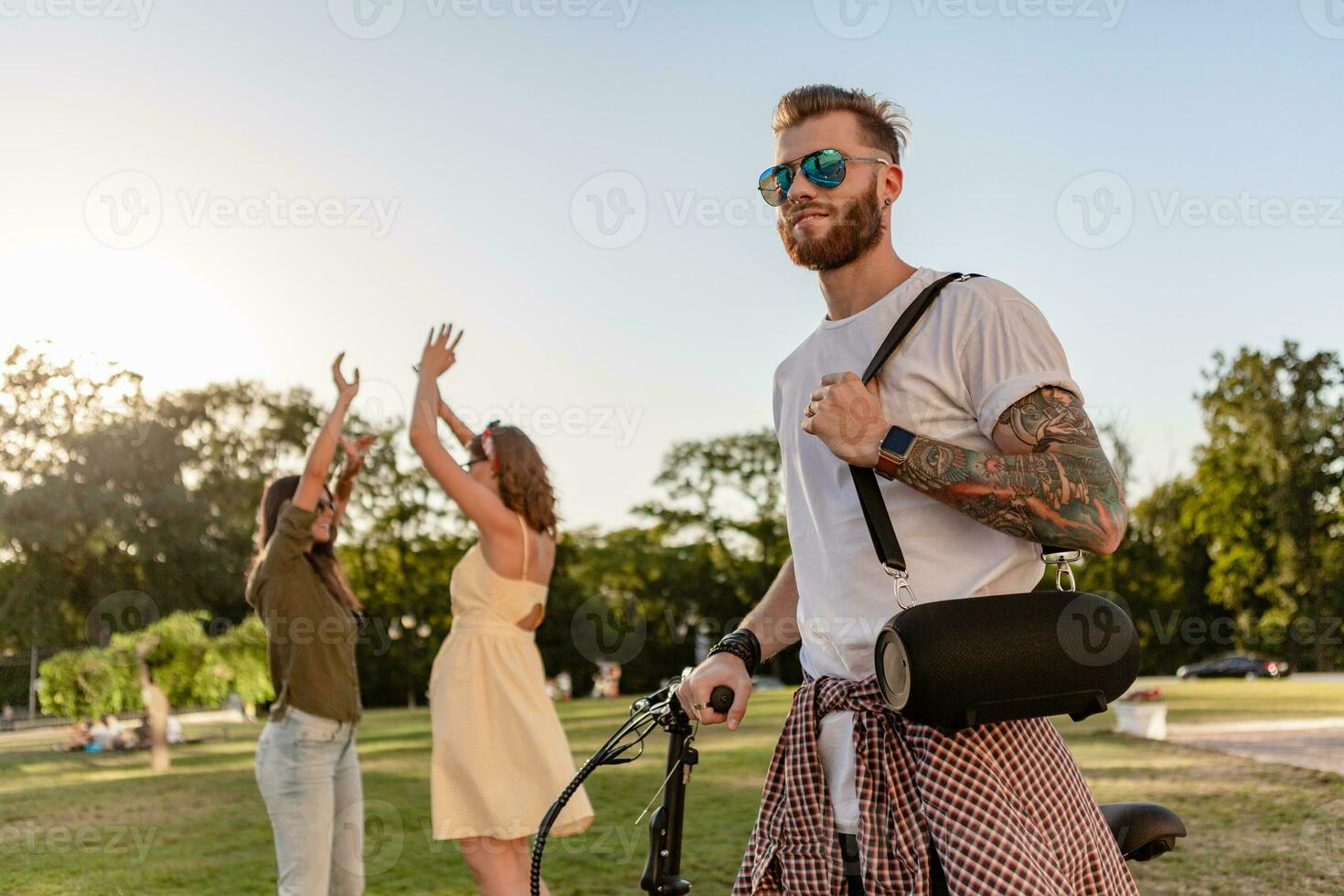 company of friends having fun together in park listening to music photo