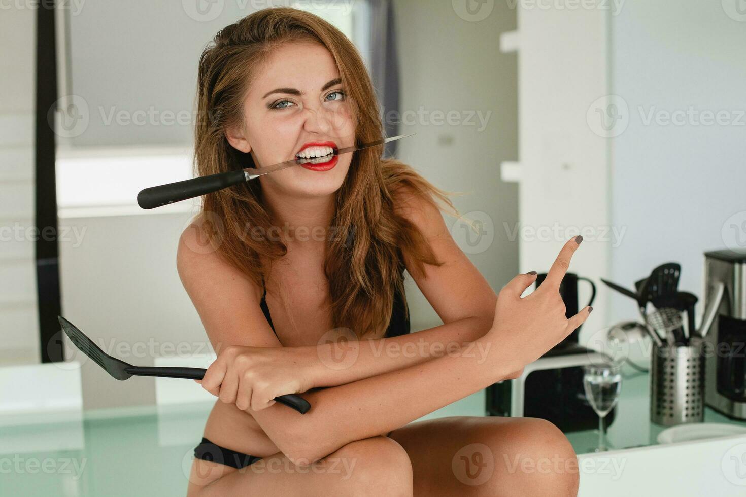 young slim beautiful woman sitting on kitchen table holding knife, sexy, black underwear, housewife, sensual, dinning room, household appliances, skinny body, tanned skin photo