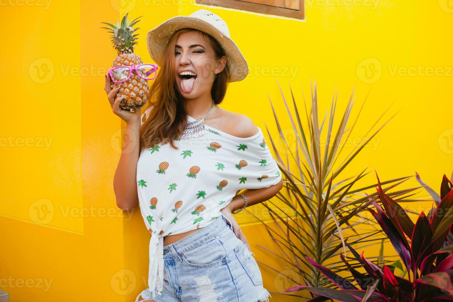attractive smiling woman on vacation holding pineapple photo