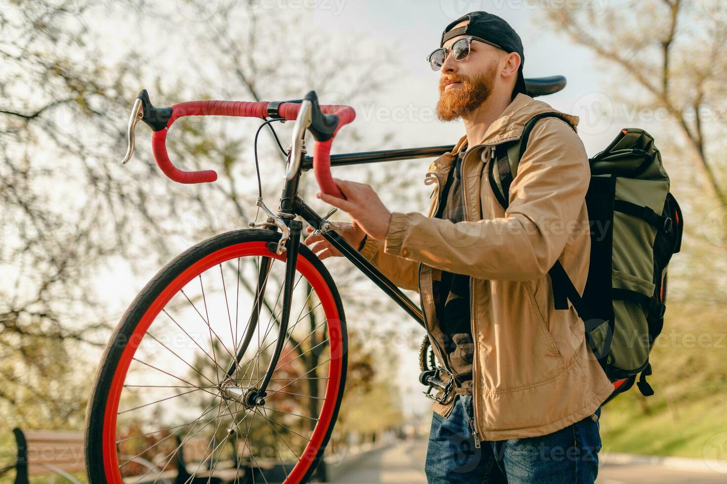 handsome bearded man traveling with bicycle in morning photo