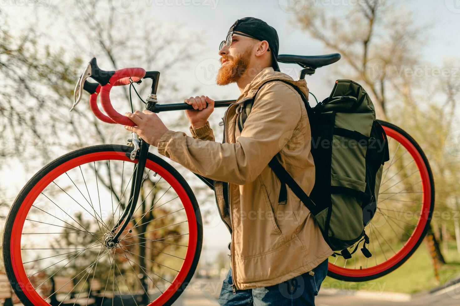 handsome bearded man traveling with bicycle in morning photo