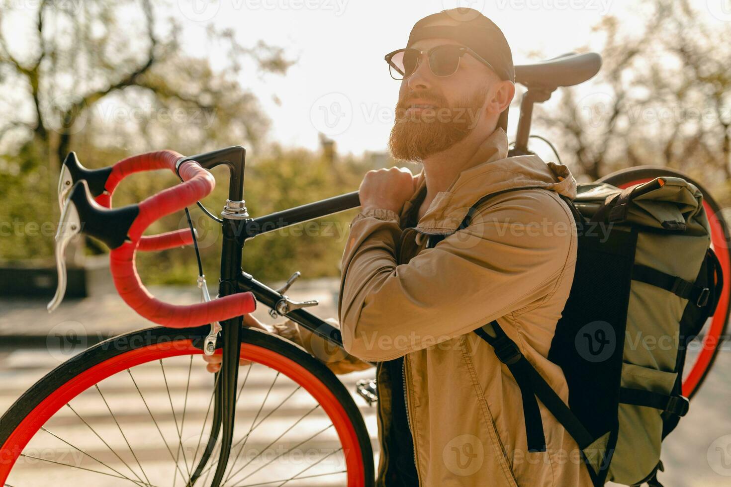 handsome bearded man traveling with bicycle in morning photo