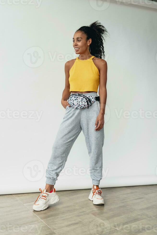 attractive black african american woman posing in stylish hipster outfit on white background photo