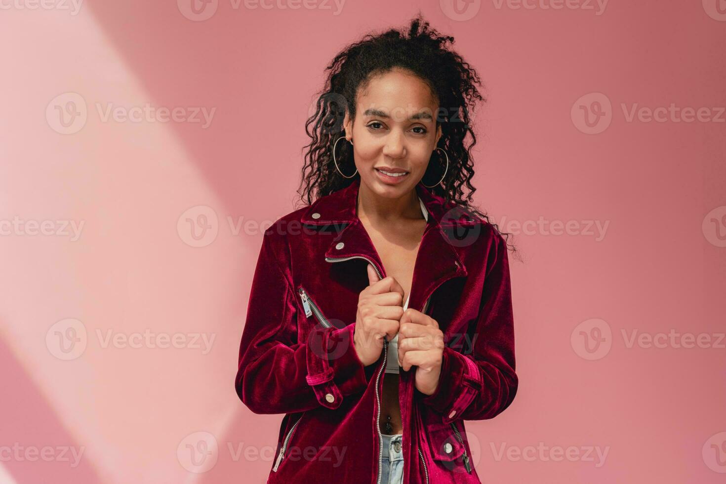 attractive black african american woman in stylish outfit on pink background photo