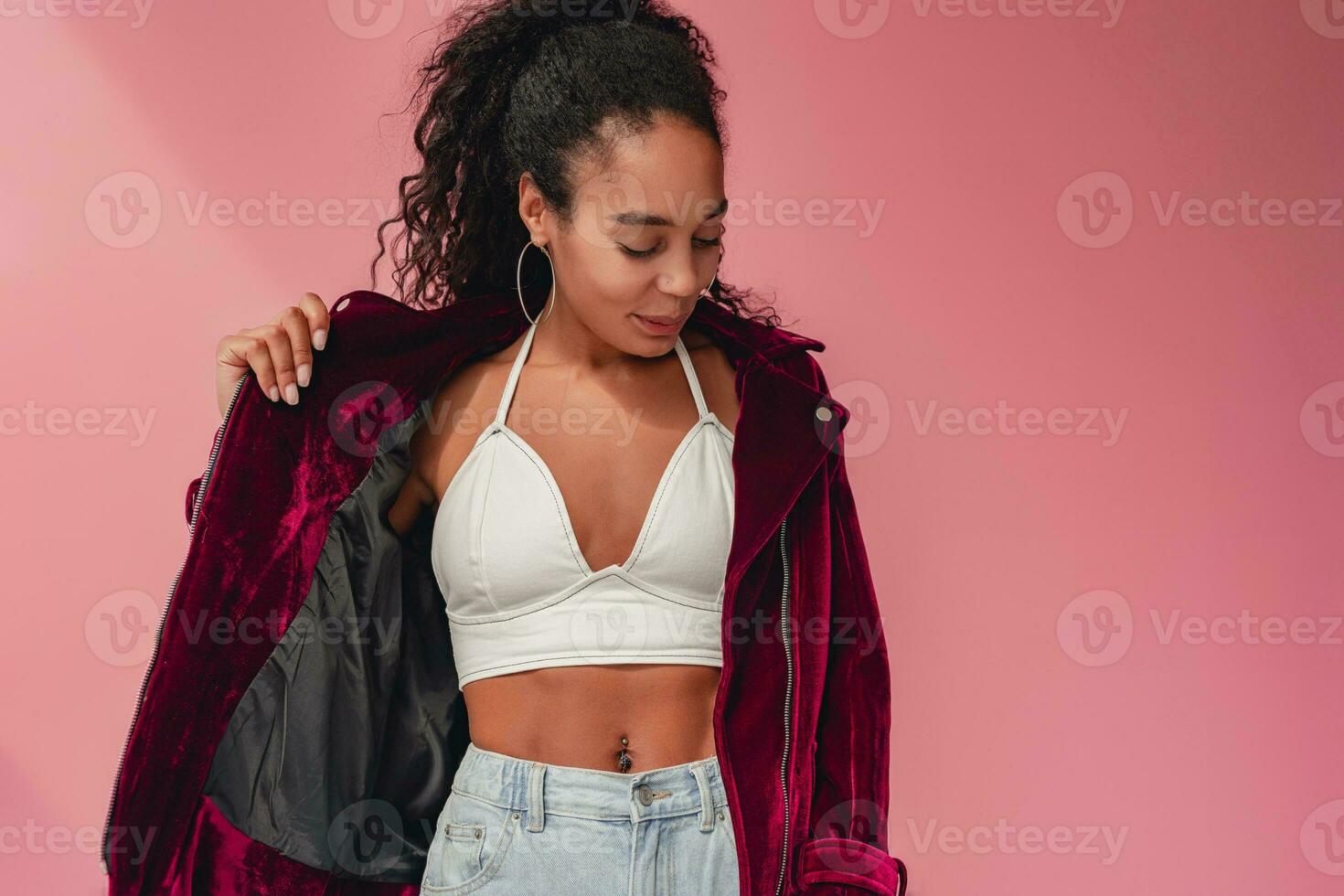 attractive black african american woman in stylish outfit on pink background photo